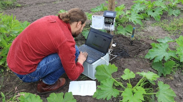 A man working on a laptop on a farm