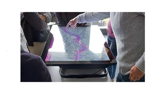 researchers pointing at a map table