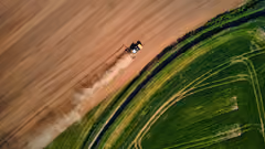 A drone shot of a machine on a dry patch of land