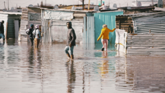 residents of a community walking through a flooded street