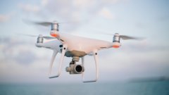 A quadcopter drone with a camera in flight