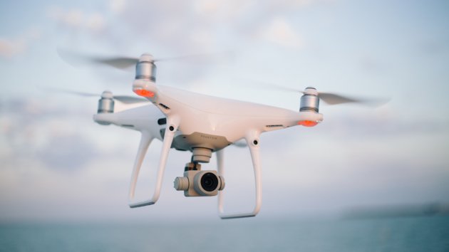 A quadcopter drone with a camera in flight